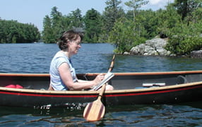 Photograph of Anne Diggory painting in a canoe